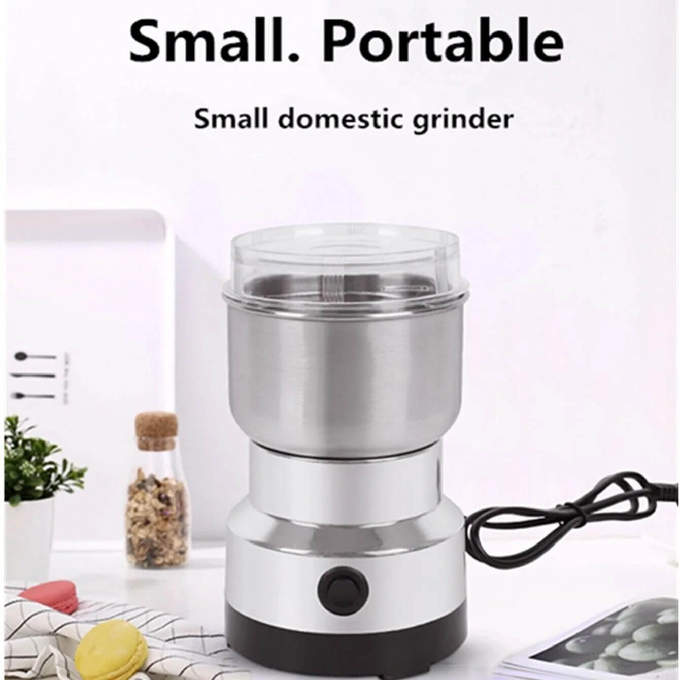 A small portable electric grinder with a stainless steel jar, clear lid, and black base, shown on a light background with text reading 'Small. Portable' and 'Small domestic grinder.